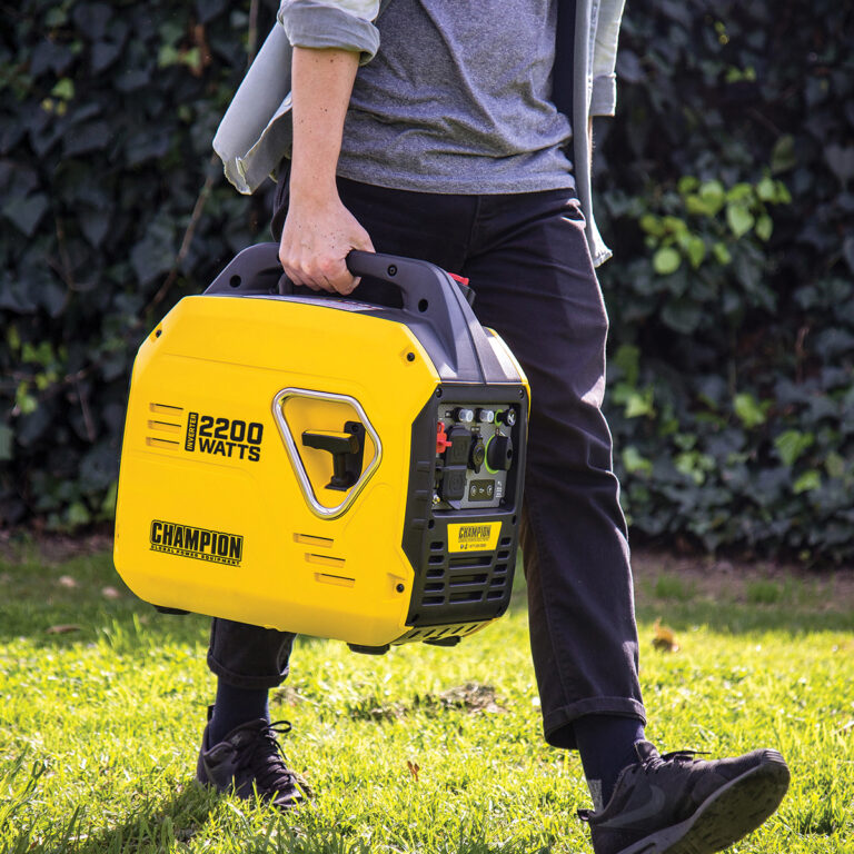 Man carrying Yellow and black 'The Mighty Atom' Champion 92001i Inverter Petrol Generator.
