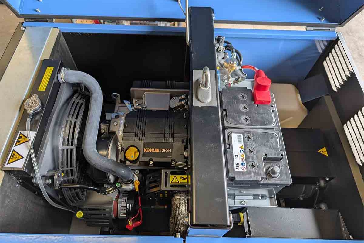 The mechanism inside an open blue Kohler diesel generator.